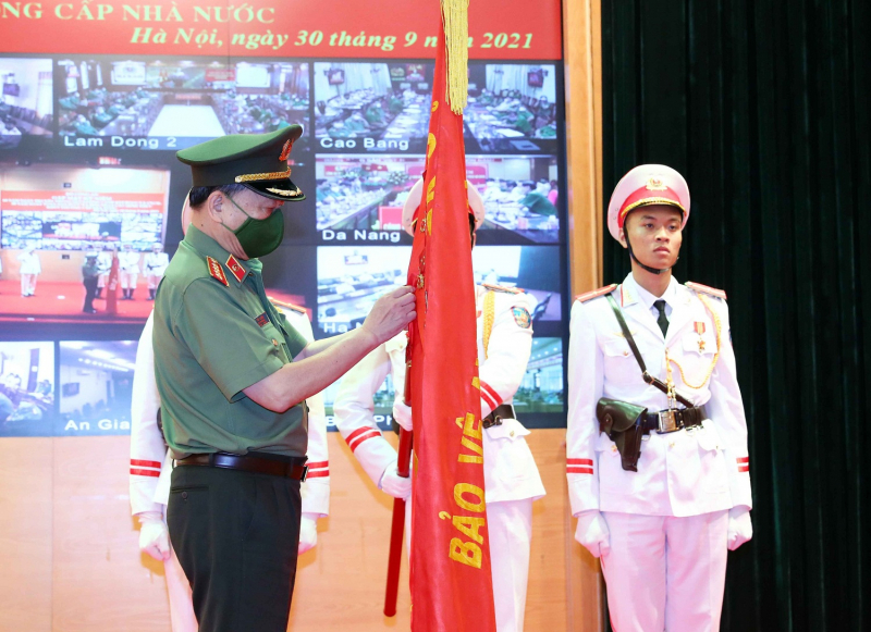 Thừa ủy quyền của Chủ tịch nước, Bộ trưởng Tô Lâm gắn Huân chương Quân công hạng Nhì lên  Cờ truyền thống của Cục Cảnh sát PCCC và CNCH.