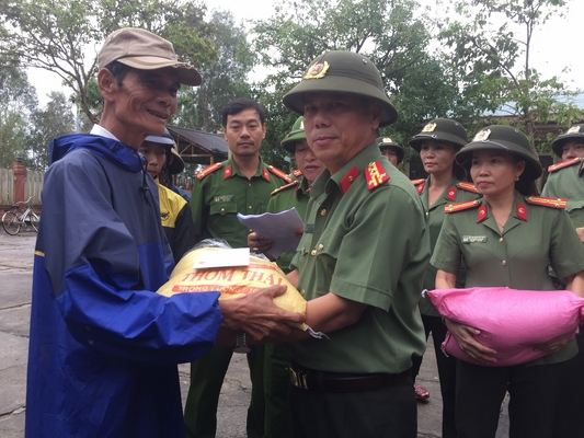 Đại tá Nguyễn Văn Thanh - Giám đốc Công an tỉnh trao quà cho người dân vùng lũ